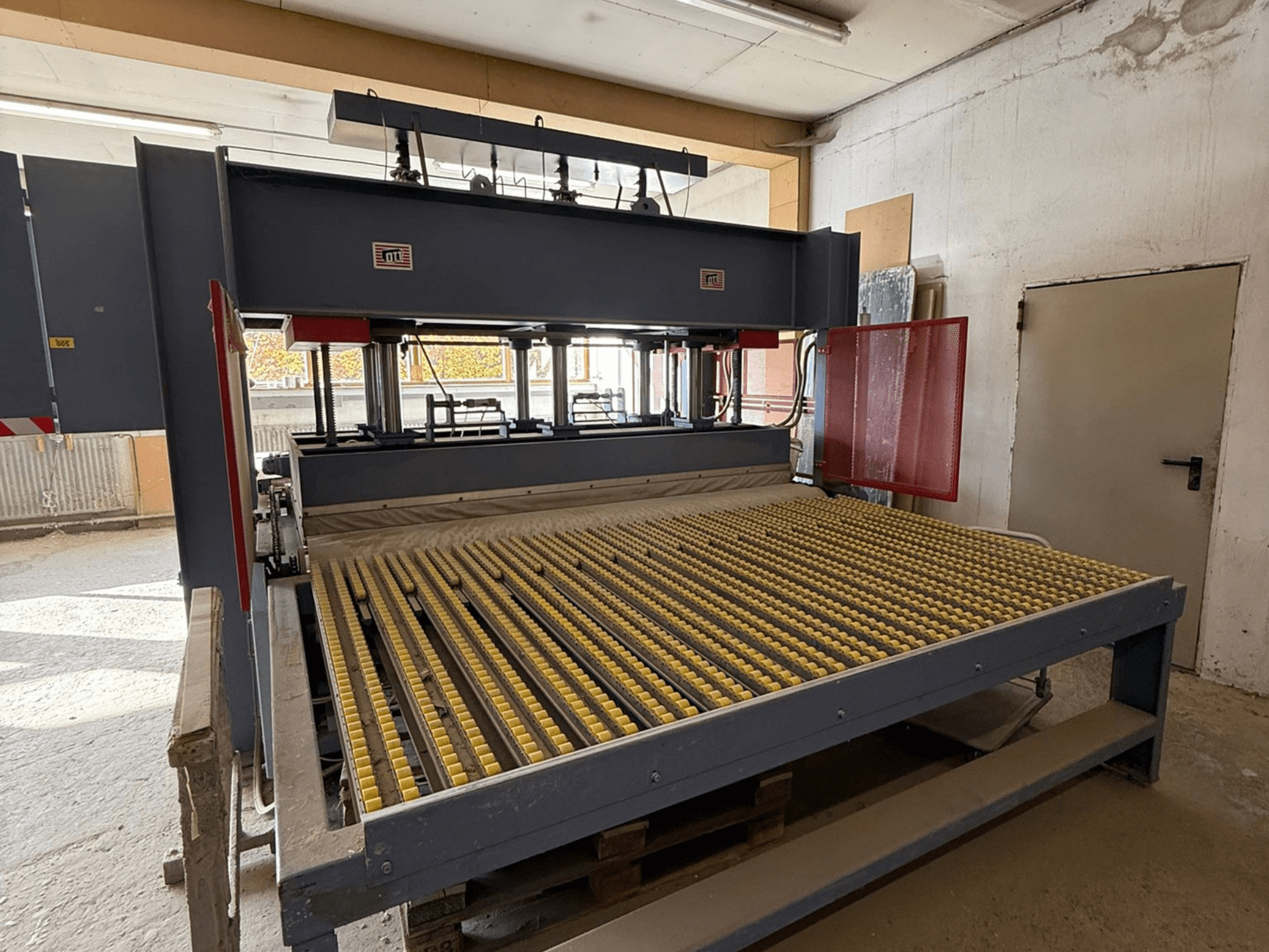 Sarı silindirli endüstriyel makine, önden görünüm, marka logosu görünür, bir atölye ortamında malzemeleri işlemek için kullanılır.