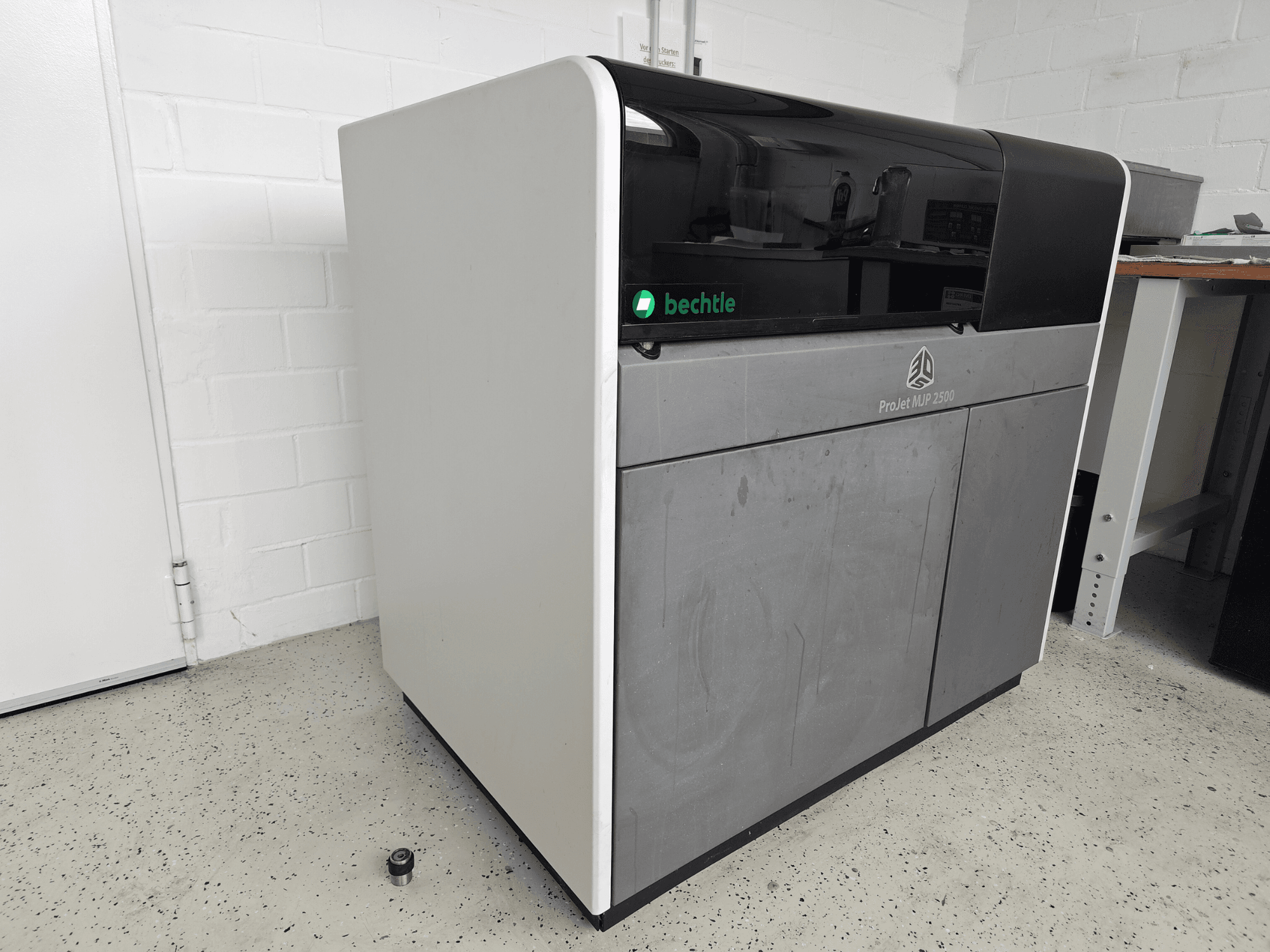 3D Systems ProJet MJP 2500 Plus plastik yazıcının önden görünümü; koyu renkli üst kısmı ve açık renkli gövdesi ile şık bir tasarıma sahiptir.