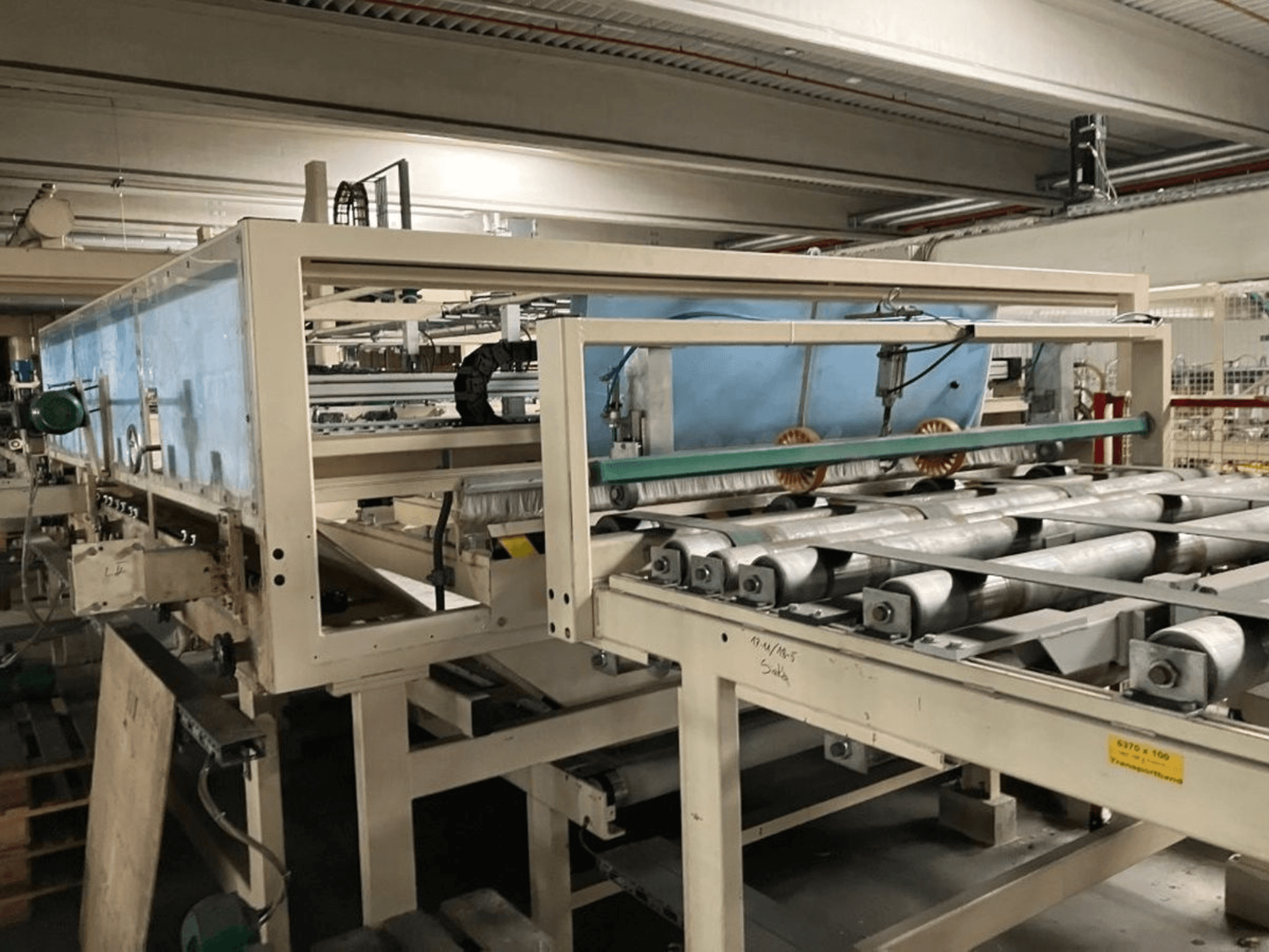 WEMHÖNER KT-F-1E laminasyon presi, yandan görünüm, fabrika ortamında malzeme işleme için silindirler ve kontroller içerir.