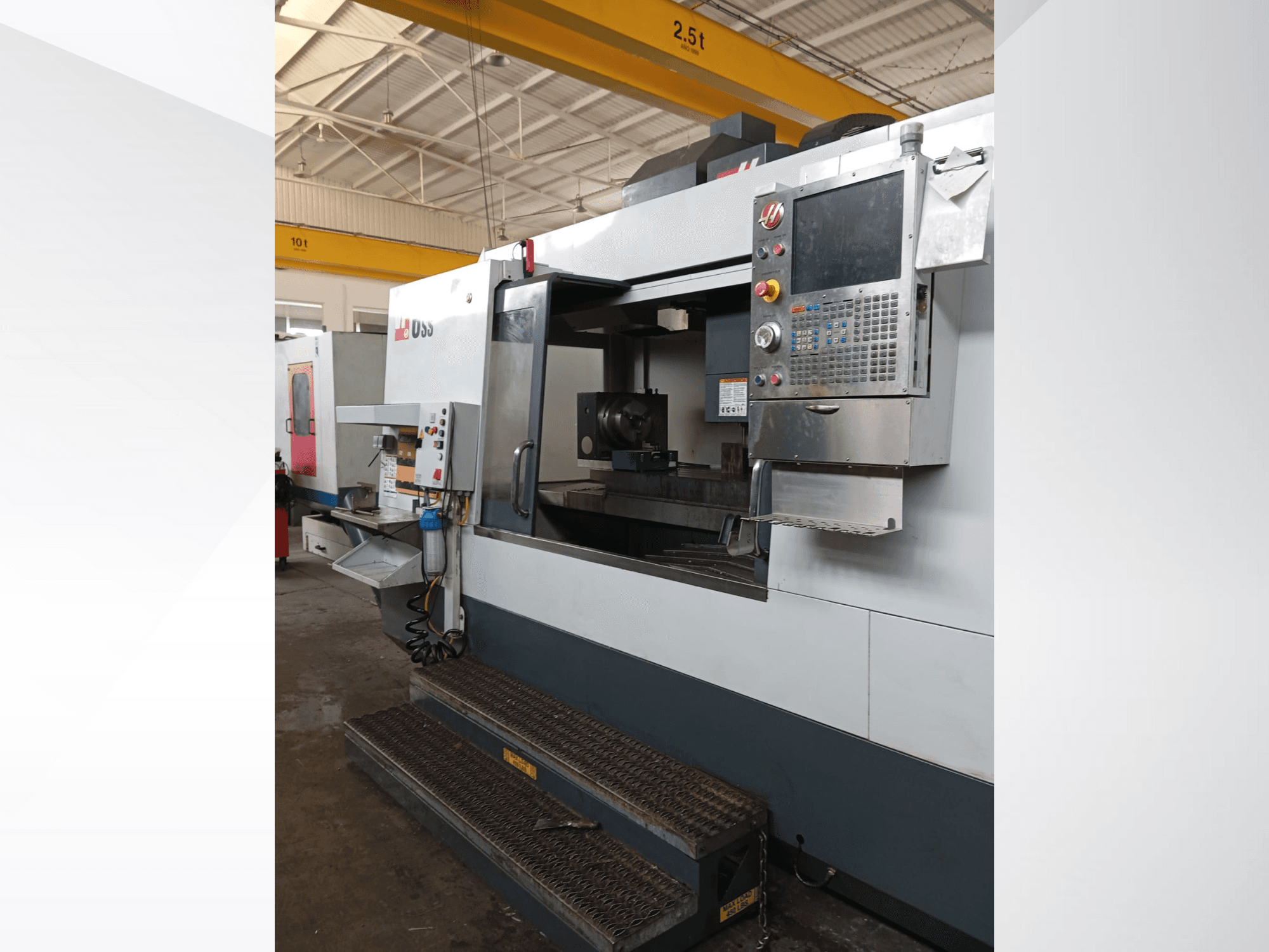 Haas CNC freze makinesi, önden görünüm, kontrol panelini, çalışma alanını ve erişim için ayrıntılı adımları gösterir.