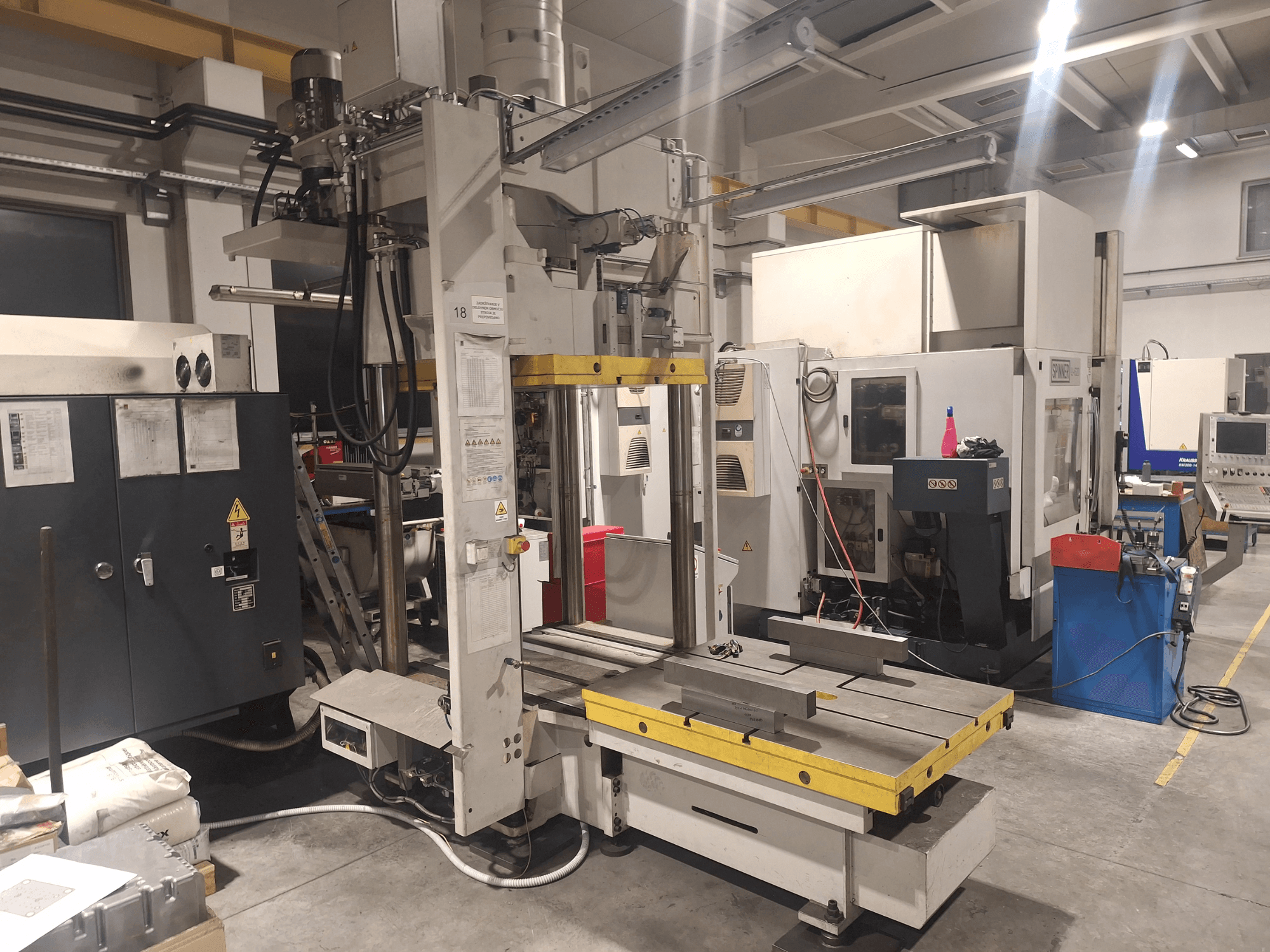 Synergic'in yatay freze makinesi, önden görünüm; atölye ortamında geniş bir tabla ve çeşitli kontrol panellerine sahiptir.