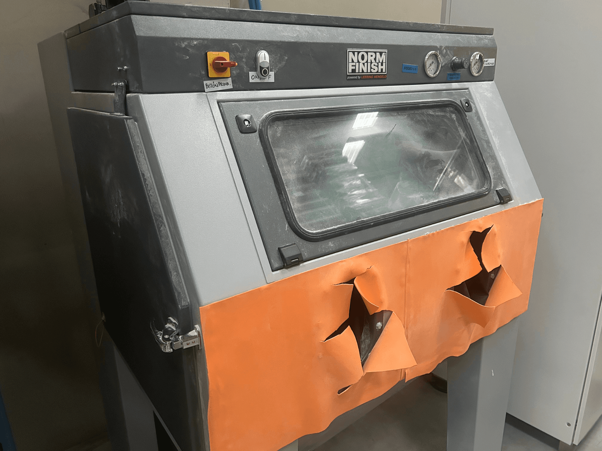 EOS P 396 gri plastik 3D yazıcı, yıpranmış turuncu kapak ve görünür kontrol paneli ile yandan görünüm, tozlu durum.