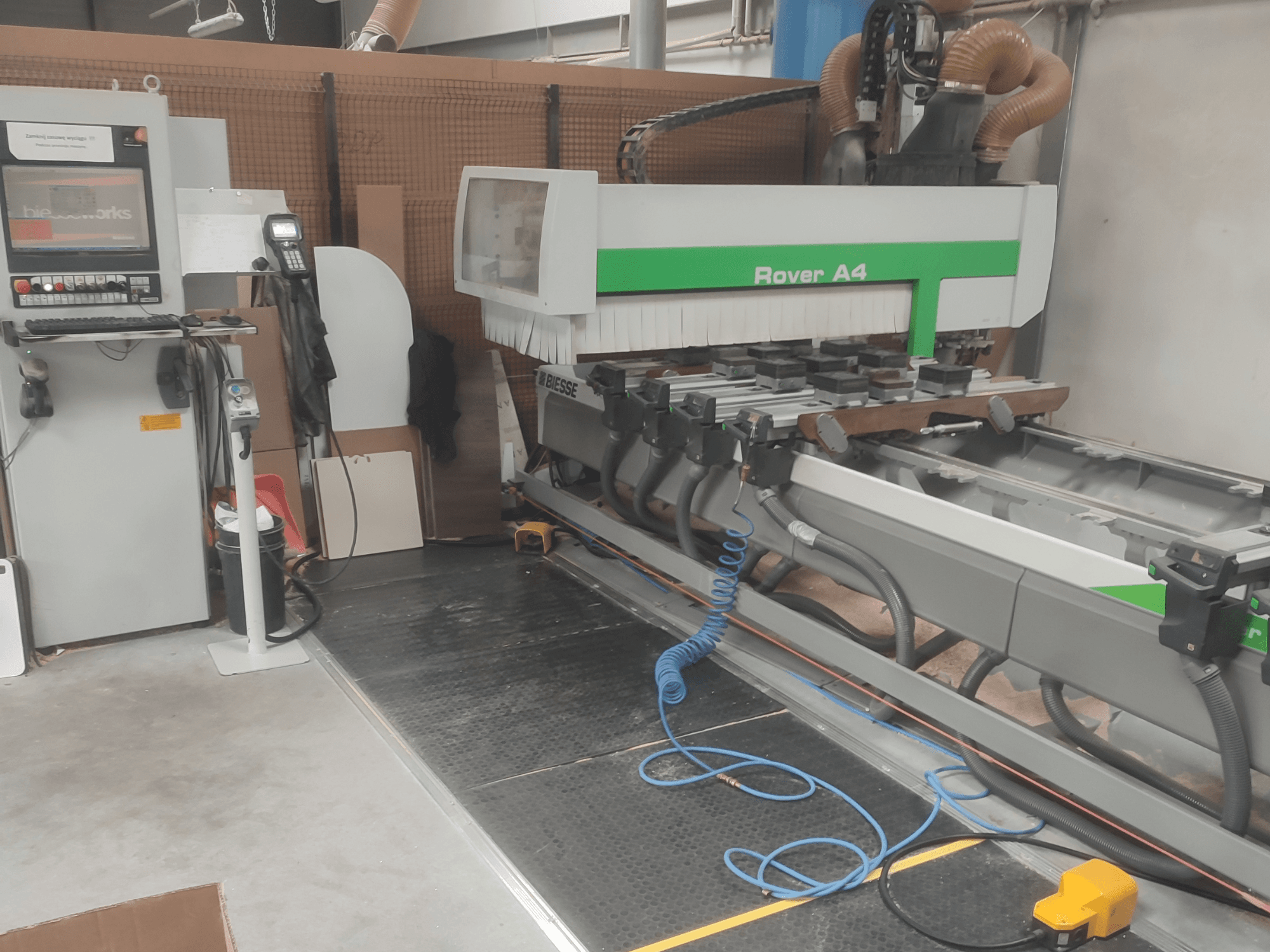 BIESSE Rover A4 CNC ahşap işleme merkezinin yandan görünümü; kontrol paneli, vakumlu tutucular ve toz emme sistemi görülmektedir.