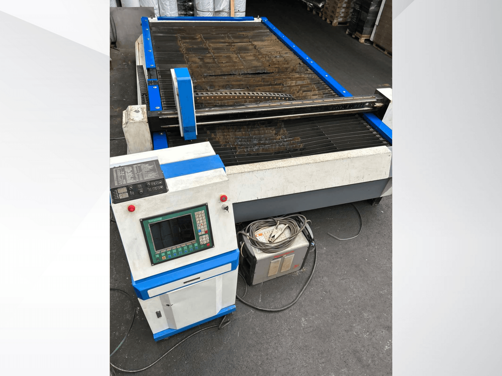 Kontrol panelli CNC plazma kesme makinesi, önden görünüm, mavi vurgular ve zeminde kablolar.