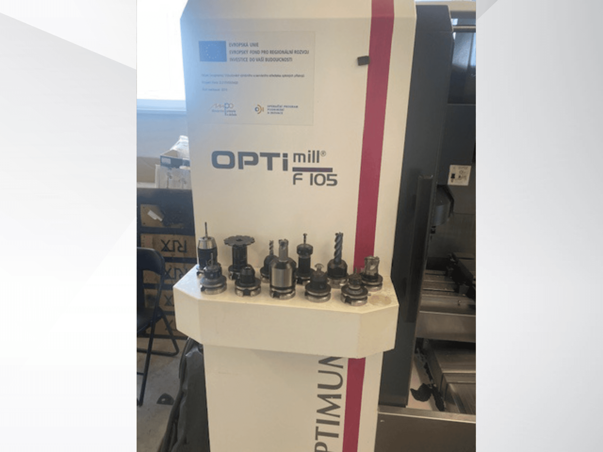 Optimum Optimill F105 dikey işleme merkezinin önden görünümü; yan tarafta çeşitli takılı aletler gösterilmektedir.