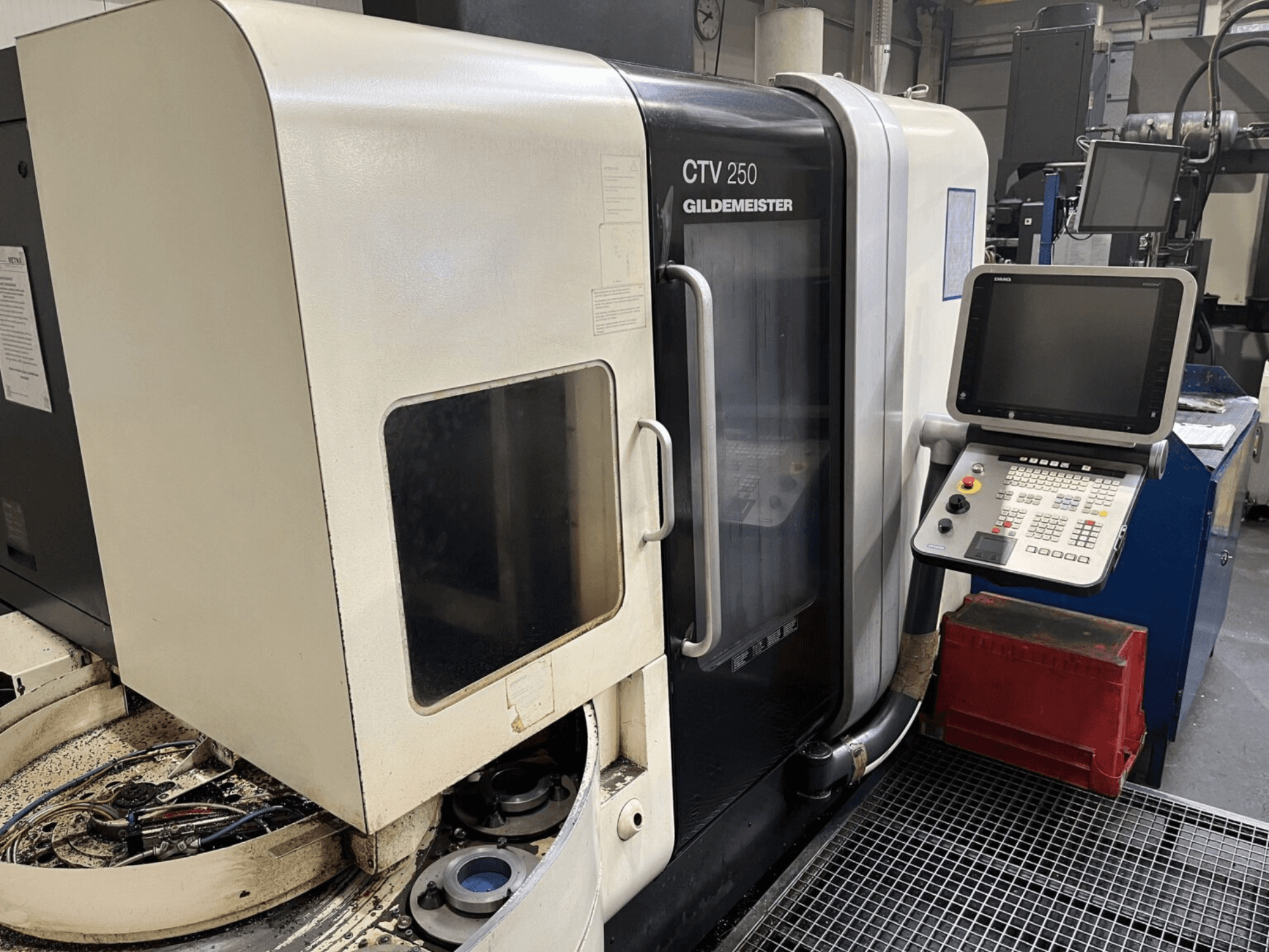 DMG CTV-250 dikey tornalama makinesinin önden görünümü, kontrol paneli ve takımların bulunduğu çalışma alanı.