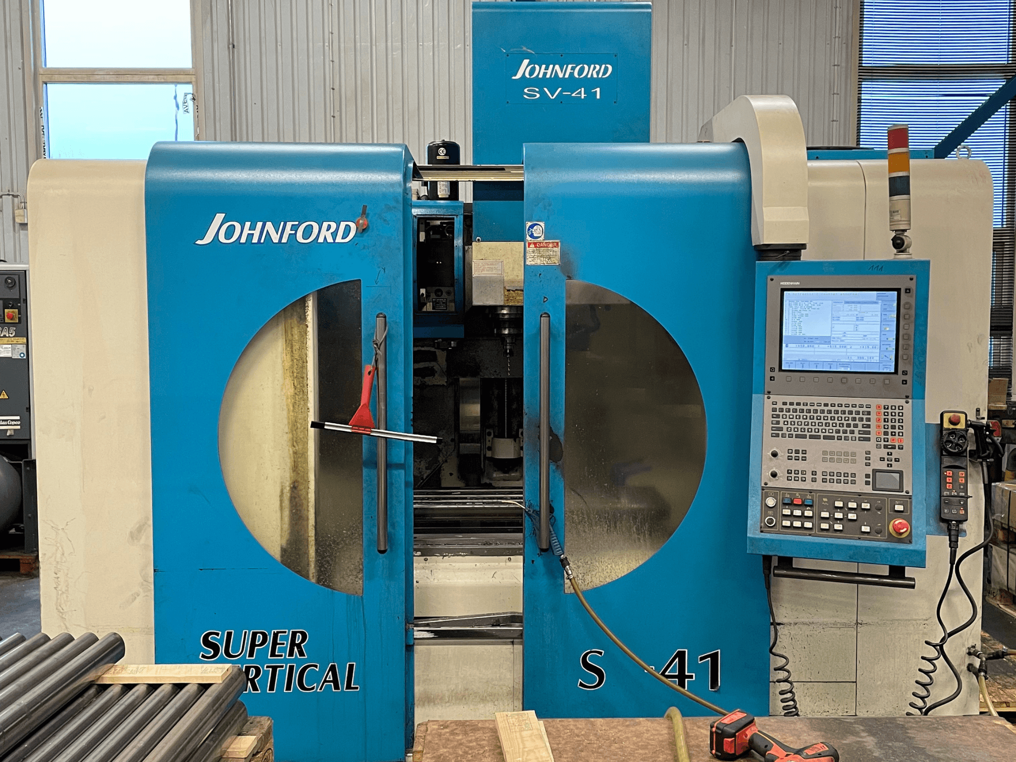 Johnford SV-41 dikey işleme merkezinin önden görünümü, bir kontrol paneli ve net görüntüleme pencereleri içerir.