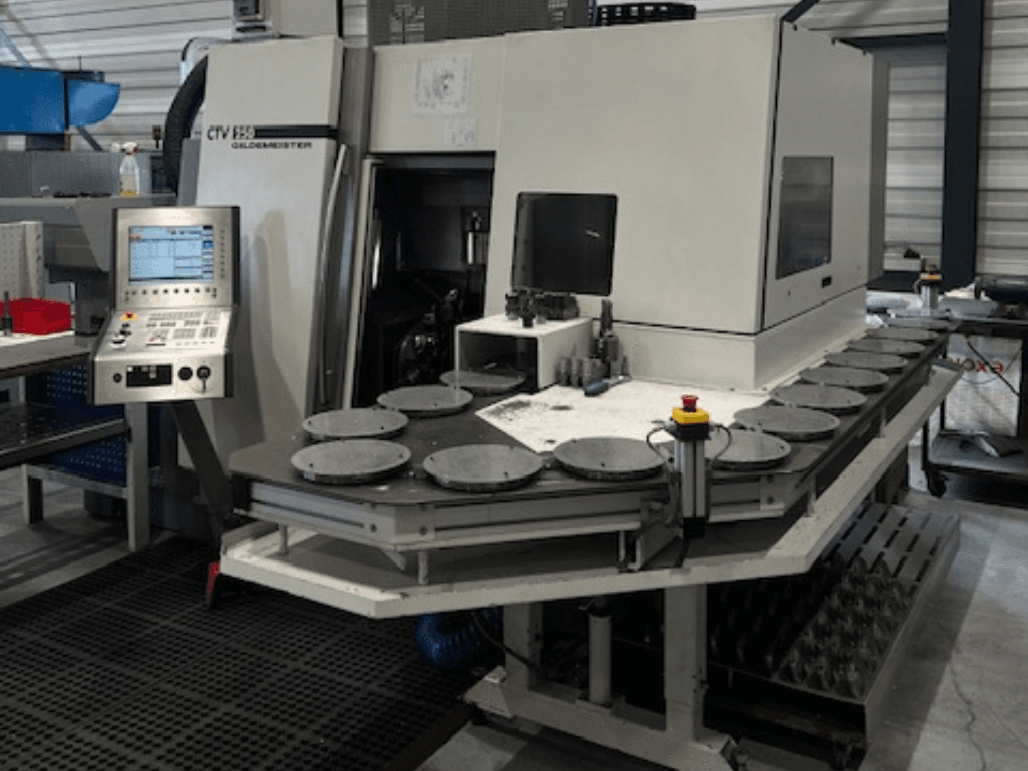 Alt metin: Atölyede CTV E33 Goldmeister işleme ünitesi, önden görünüm, kontrol paneli ve çoklu dairesel çalışma platformları.