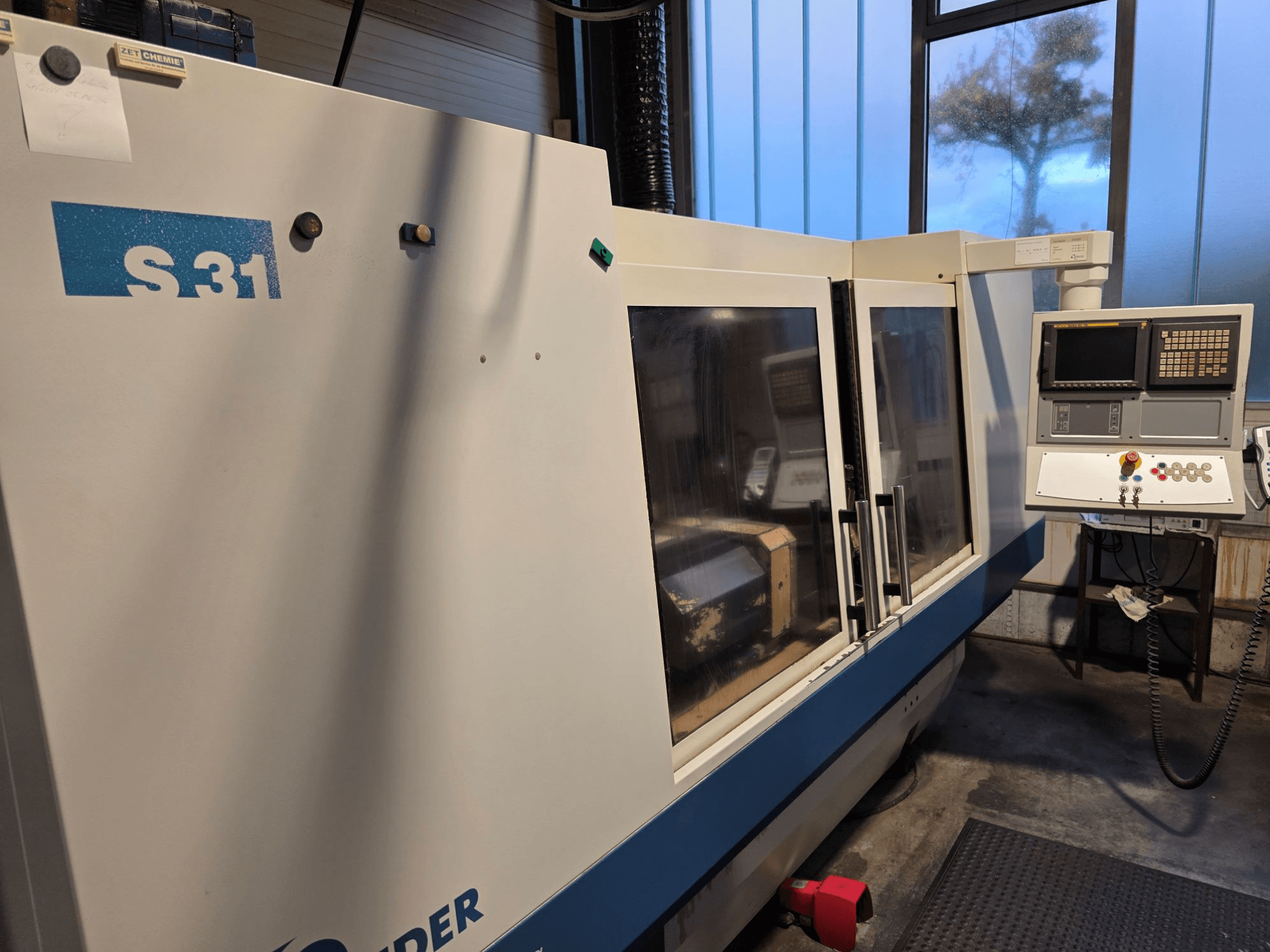 S31 CNC taşlama makinesi, önden görünüm, ekranlı ve düğmeli kontrol paneli, büyük cam kapı, endüstriyel ortam özellikleri.