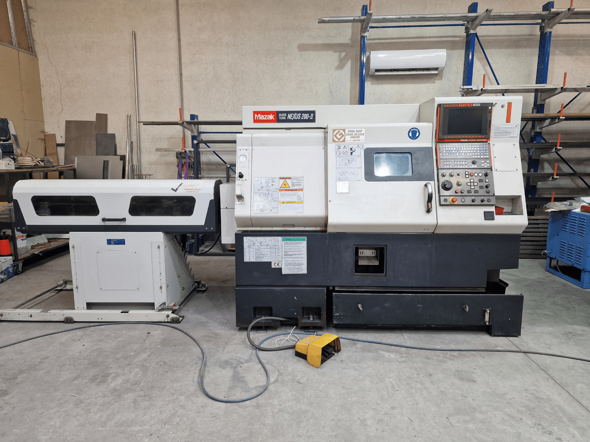 Mazak QuickTurn Nexus 200 yatay torna tezgahı, yandan görünüm; kontrol paneli, iş mili ve talaş tepsisi görülmektedir.