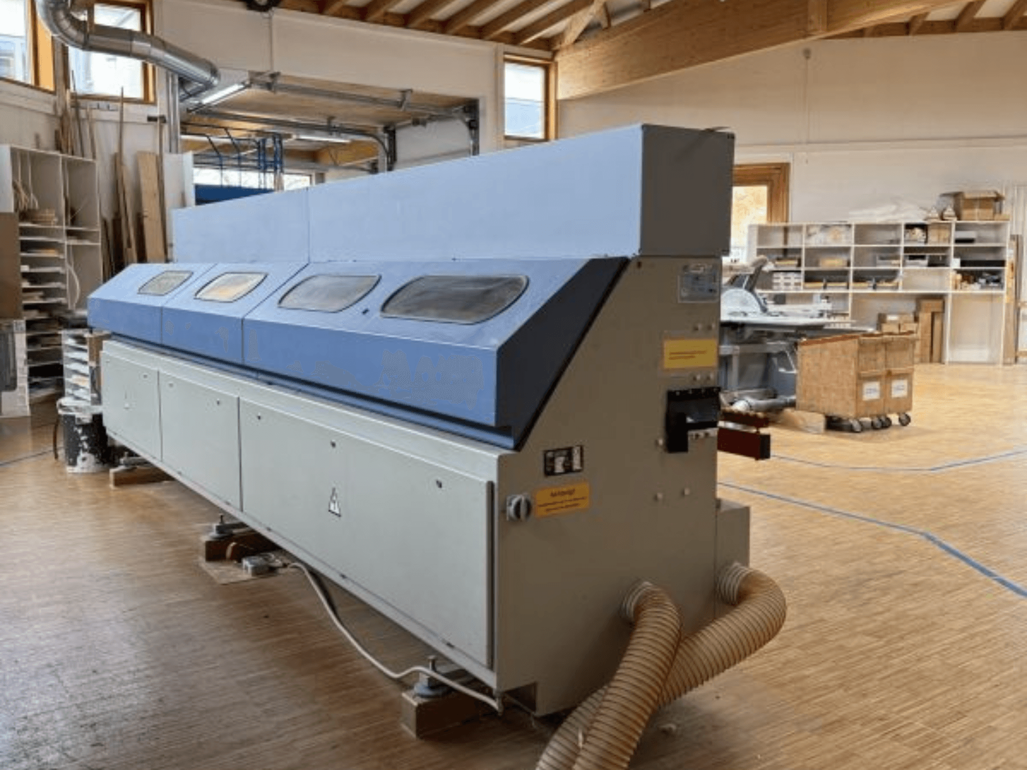 OTT Pacific V6-F kenar bantlama makinesi yandan gösterilmiştir; uzun mavi bir üst kısmı ve hortum bağlantılı kontrol paneli vardır.