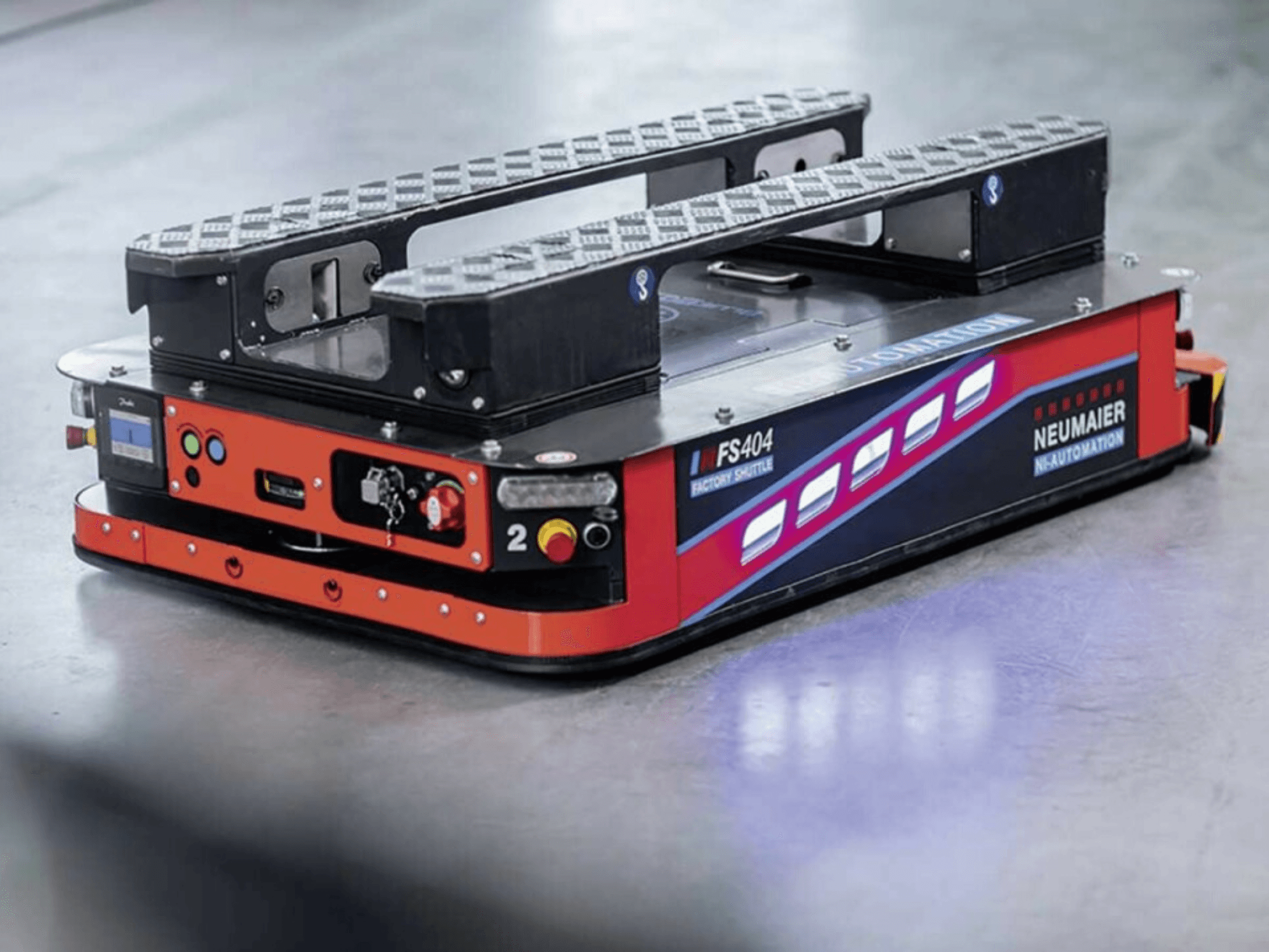 NEUMAIER AGV Factory Shuttle FS404, düşük profilli palet taşıma sistemi, tekerlekleri, kontrolleri ve güvenlik özelliklerini gösteren yandan görünüm.