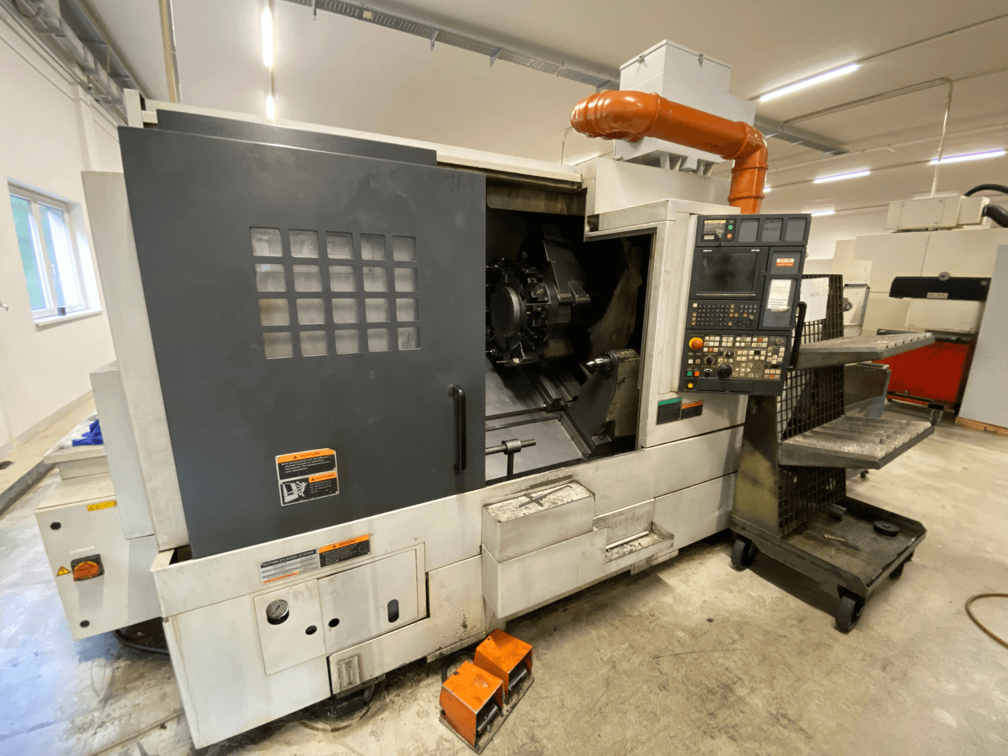 DMG Mori Seiki NL2500Y/700 torna-freze merkezi; kontrol paneli ve makine muhafazasının ayrıntılarını gösteren önden görünüm.