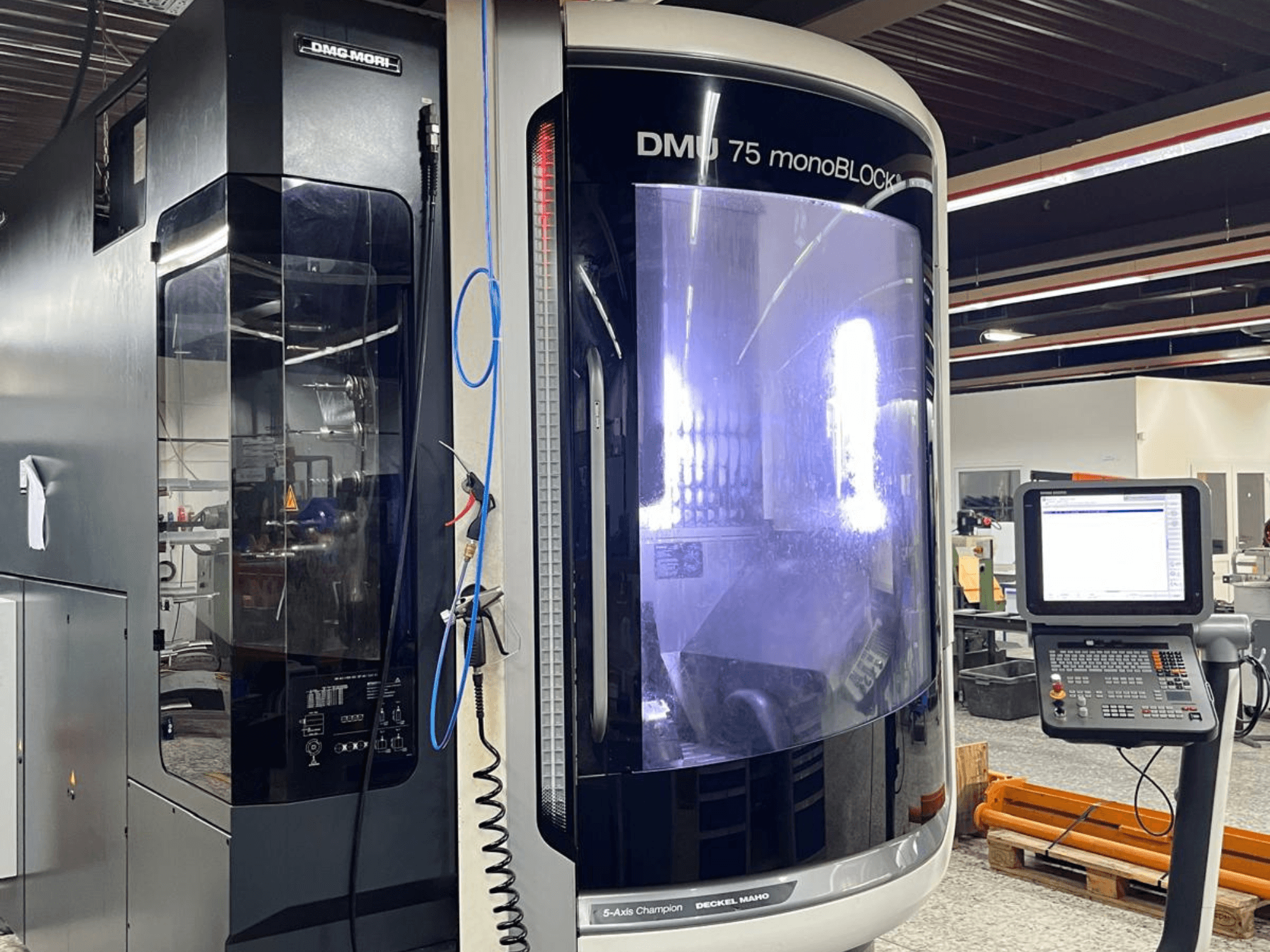 DMG MORI DMU 75 MonoBlock üniversal işleme merkezi, önden görünüm, kontrol panelini ve ayırt edici kasayı gösterir.