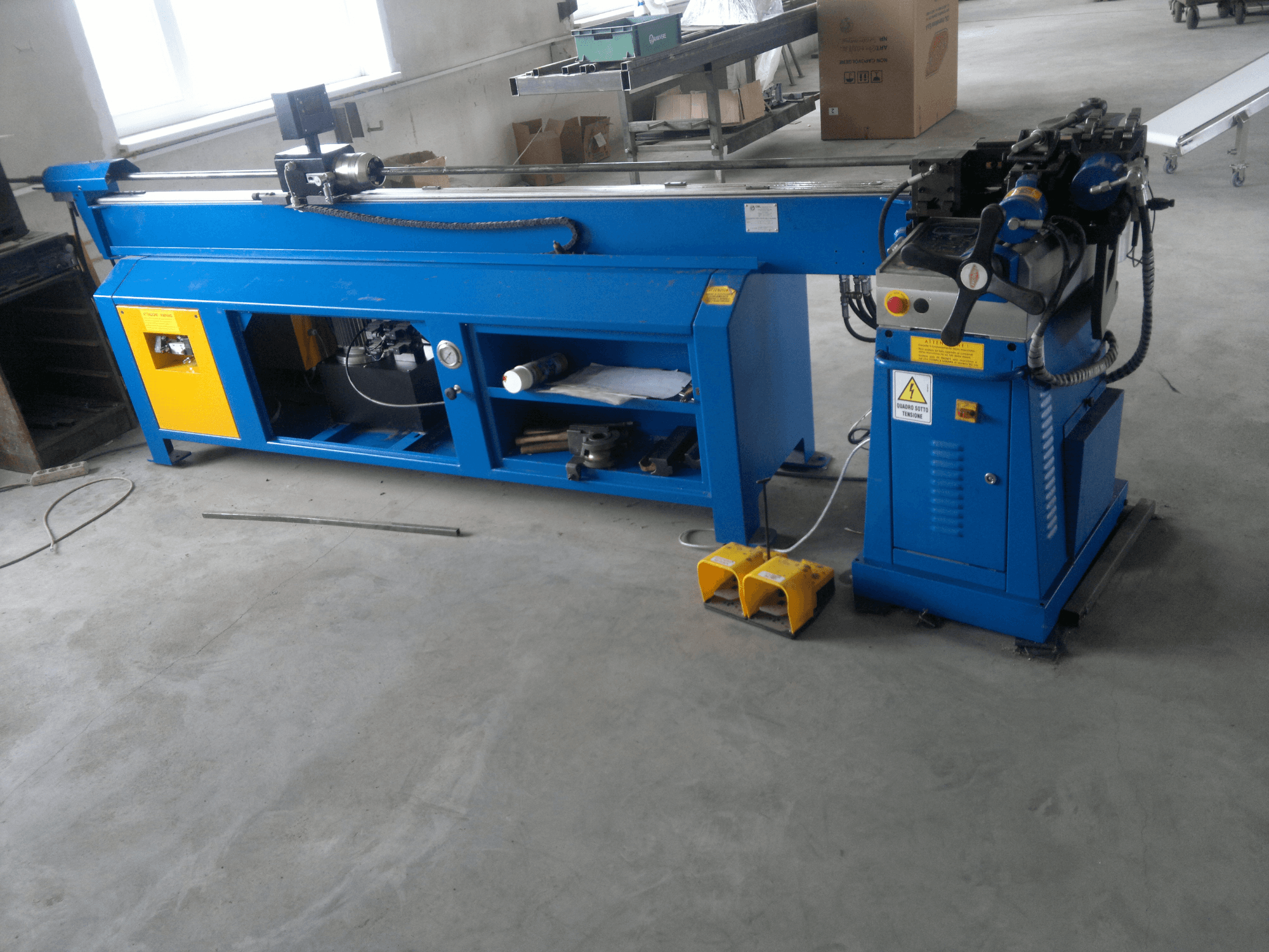 Sarı desenli mavi ahşap işleme makinesi, yandan görünüm; kontrol paneli, ayak pedalları ve döner bıçak tertibatına sahiptir.