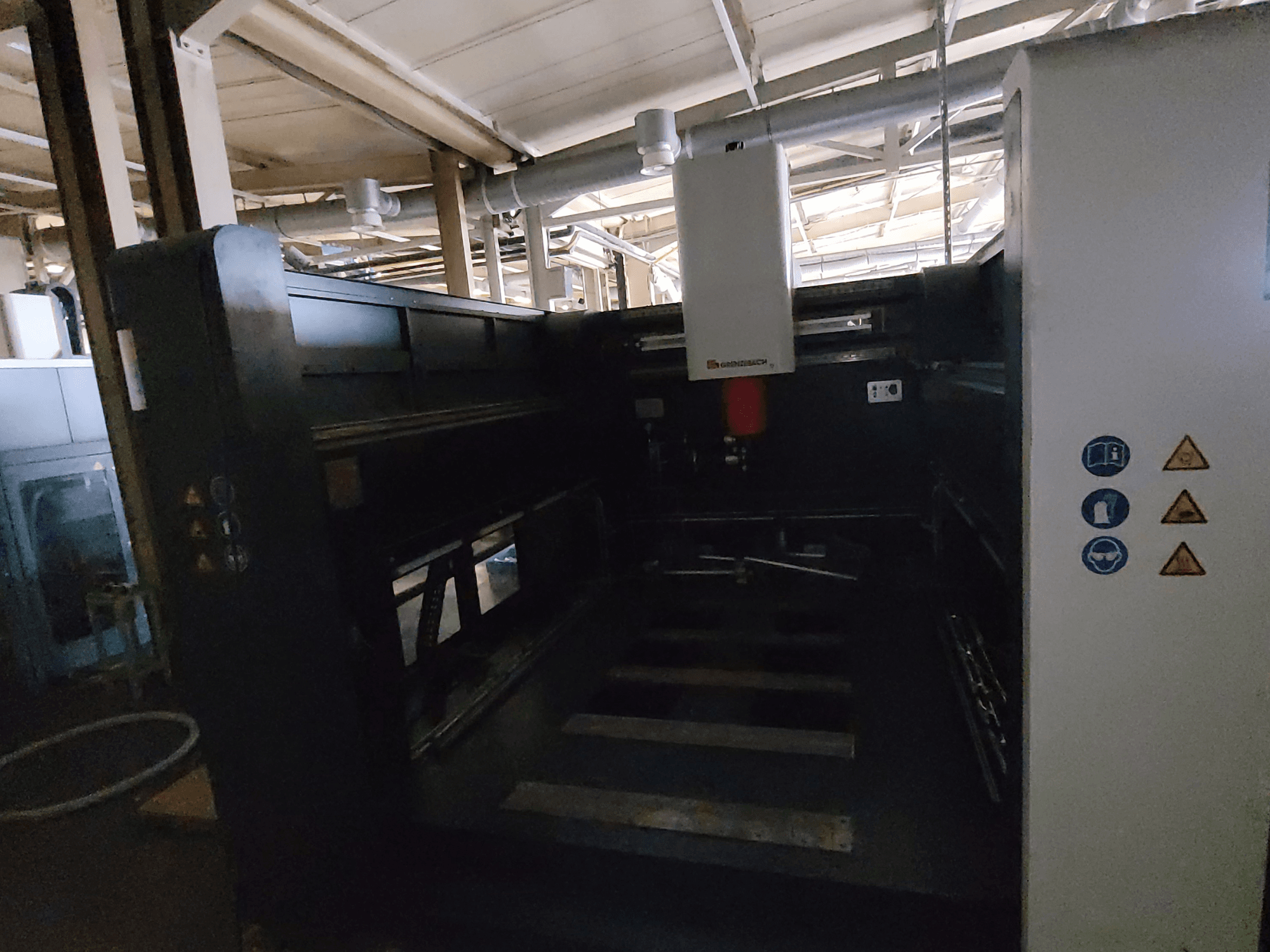 GRENZEBACH FSW Makinesi DSM 3000; kontrol panellerini, güvenlik sembollerini ve işleme işlemleri için çalışma alanını gösteren yandan görünüm.