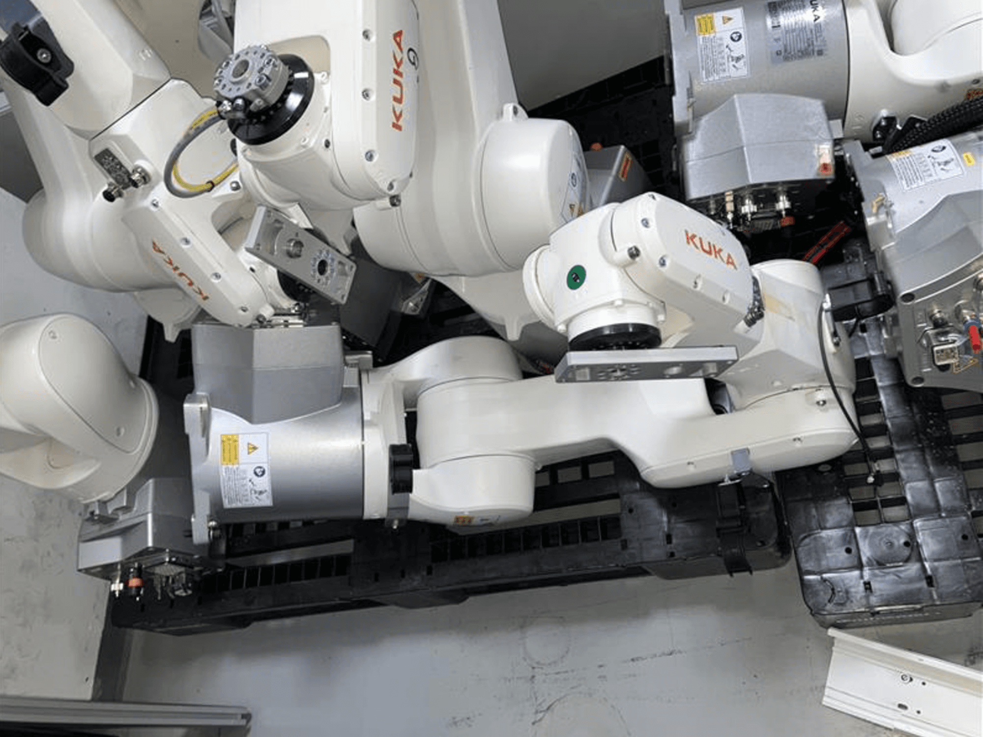 KUKA KR 10 R900-2 robot kolu yukarıdan bakıldığında mafsallı eklemleri ve tahrik motorlarını endüstriyel bir ortamda sergiliyor.