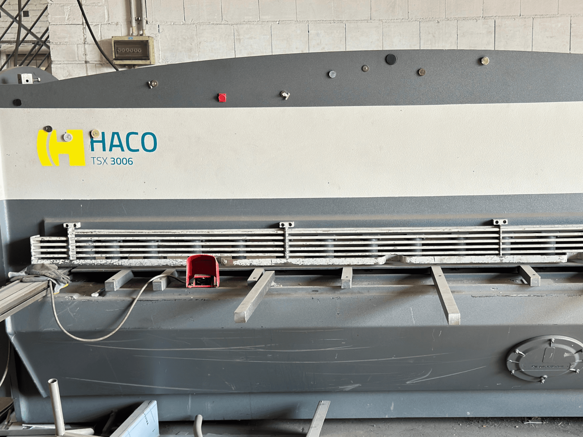 HACO TSX3006 MOT hidrolik kesme makinesi, önden görünüm, metal kesme bıçakları ve kontrol paneli, çalışma detaylarını gösterir.