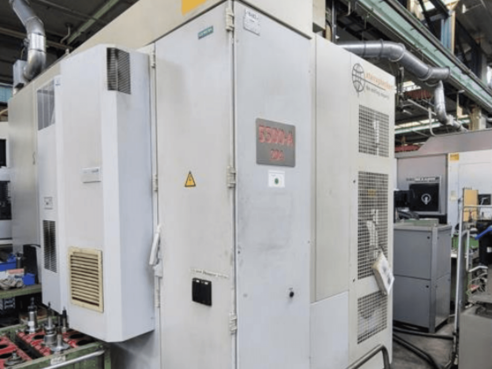 Starrag Heckert HEC 500 H/V yatay işleme merkezi, havalandırma delikleri ve uyarı levhaları ile dış görünümü gösteren yandan görünüm.