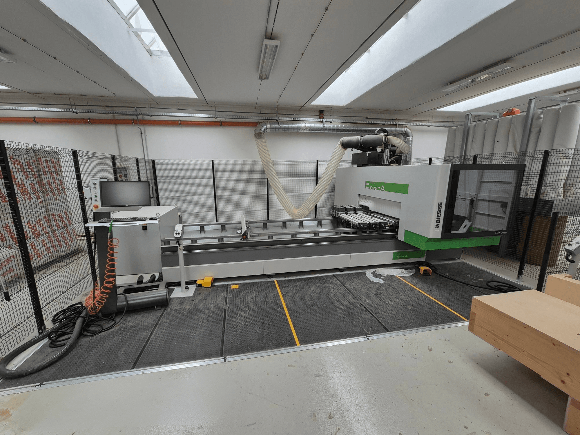 Biesse Rover Atölyede bir CNC makinesi, önden görünüm. Bir kontrol paneli, vakum sistemi ve çalışma yüzeyi içerir.