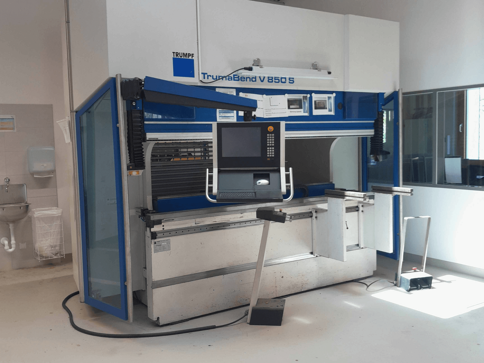 TRUMPF TrumaBend V 850 S kant press, kontrol paneli ve güvenlik özellikleriyle birlikte aydınlık bir çalışma alanında çekilmiş önden görünüm.