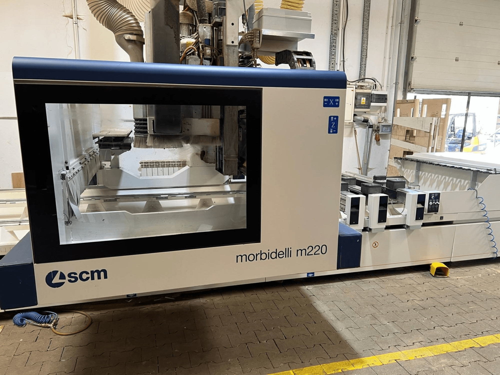 SCM Morbidelli M220 CNC İşleme Merkezi’nin önden görünümü; geniş bir pencere, kontrol paneli ve çalışma alanını göstermektedir.