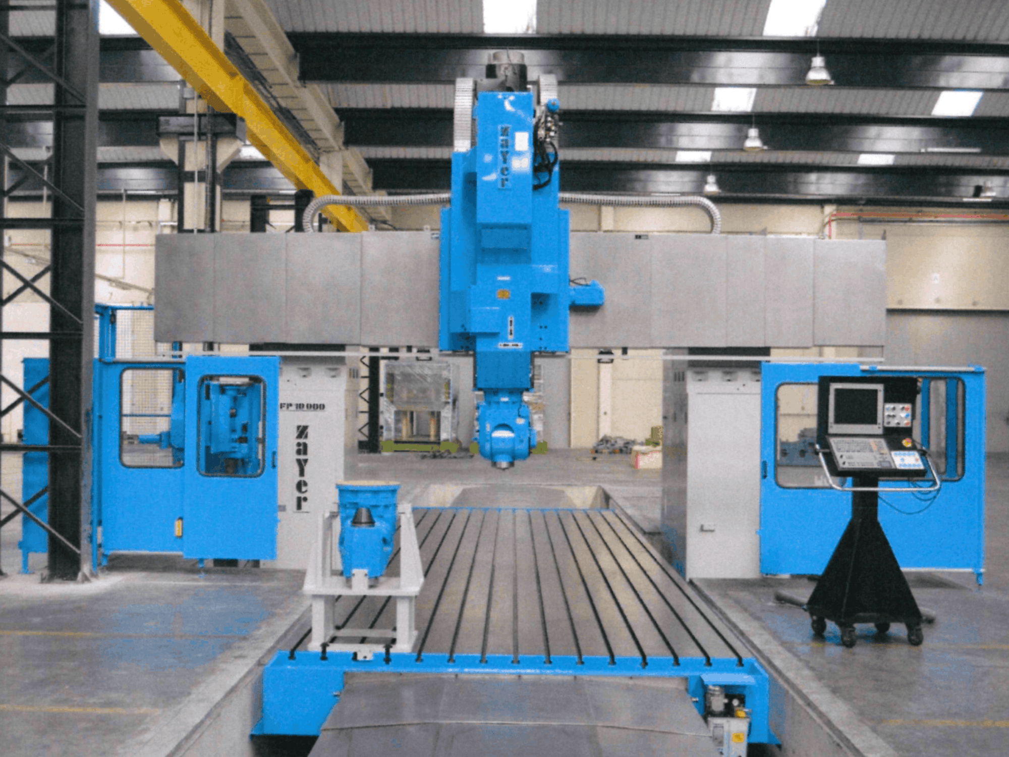 Zayer FP-10000 yatak tipi freze makinesinin önden görünümü; mavi gövdesi, kontrol paneli ve hassas bileşenleri göze çarpmaktadır.
