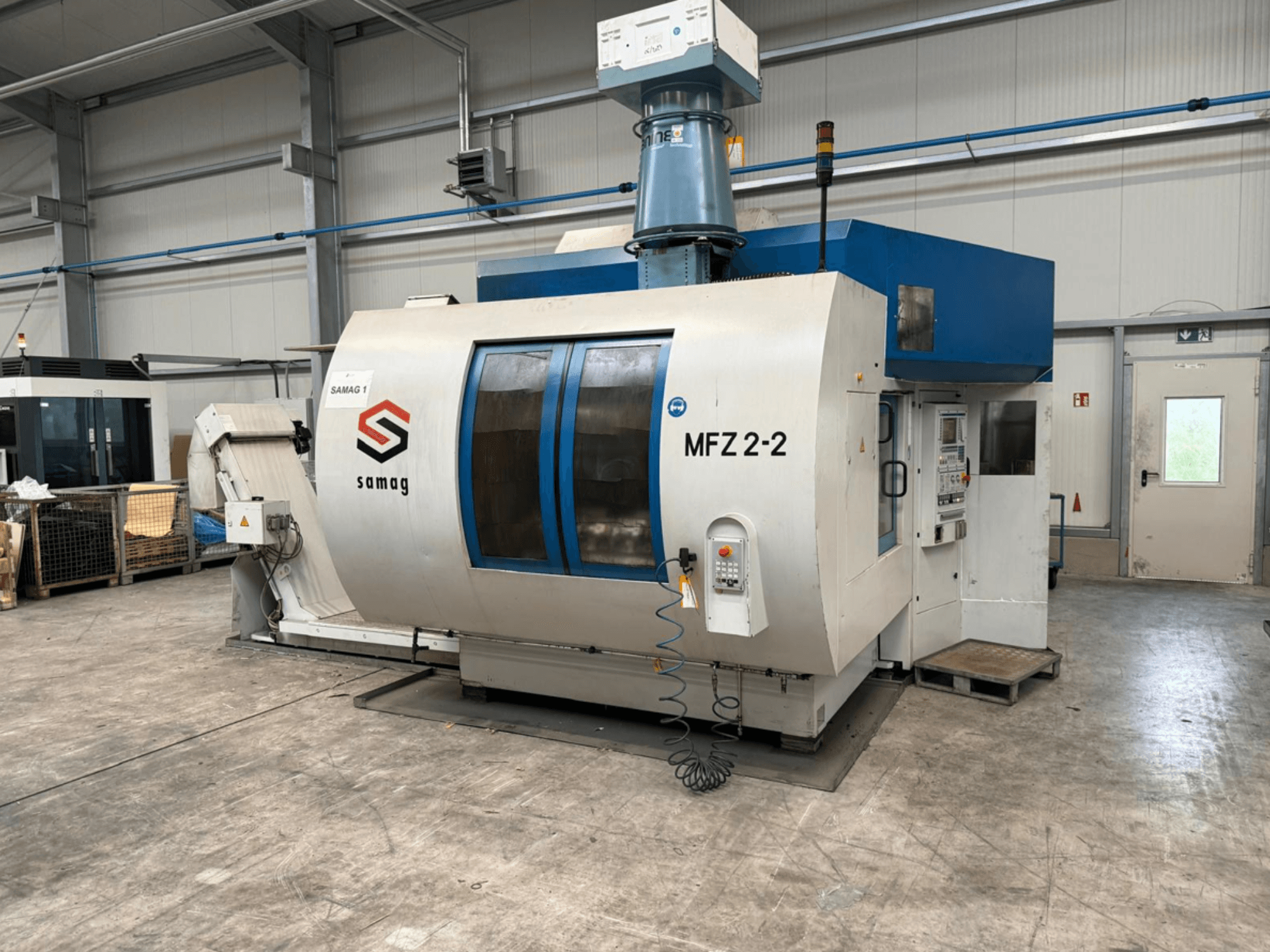 Samag MFZ 2-2 takım tezgahı, önden görünüm, kontrol panelini ve mavi üst kısmı gösteren, endüstriyel bir ortamda güvenlik özelliklerine sahip.