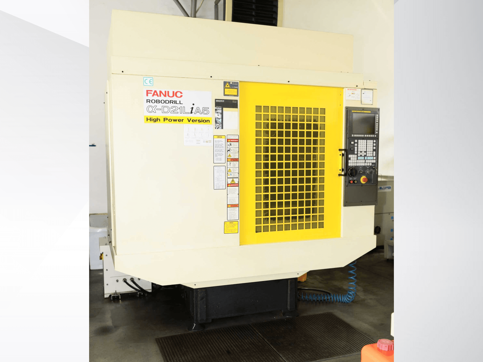 FANUC ROBODRILL α-D21LiA5 dikey işleme merkezi, sarı güvenlik ızgarası ve kontrol paneli detaylarının yer aldığı önden görünüm.