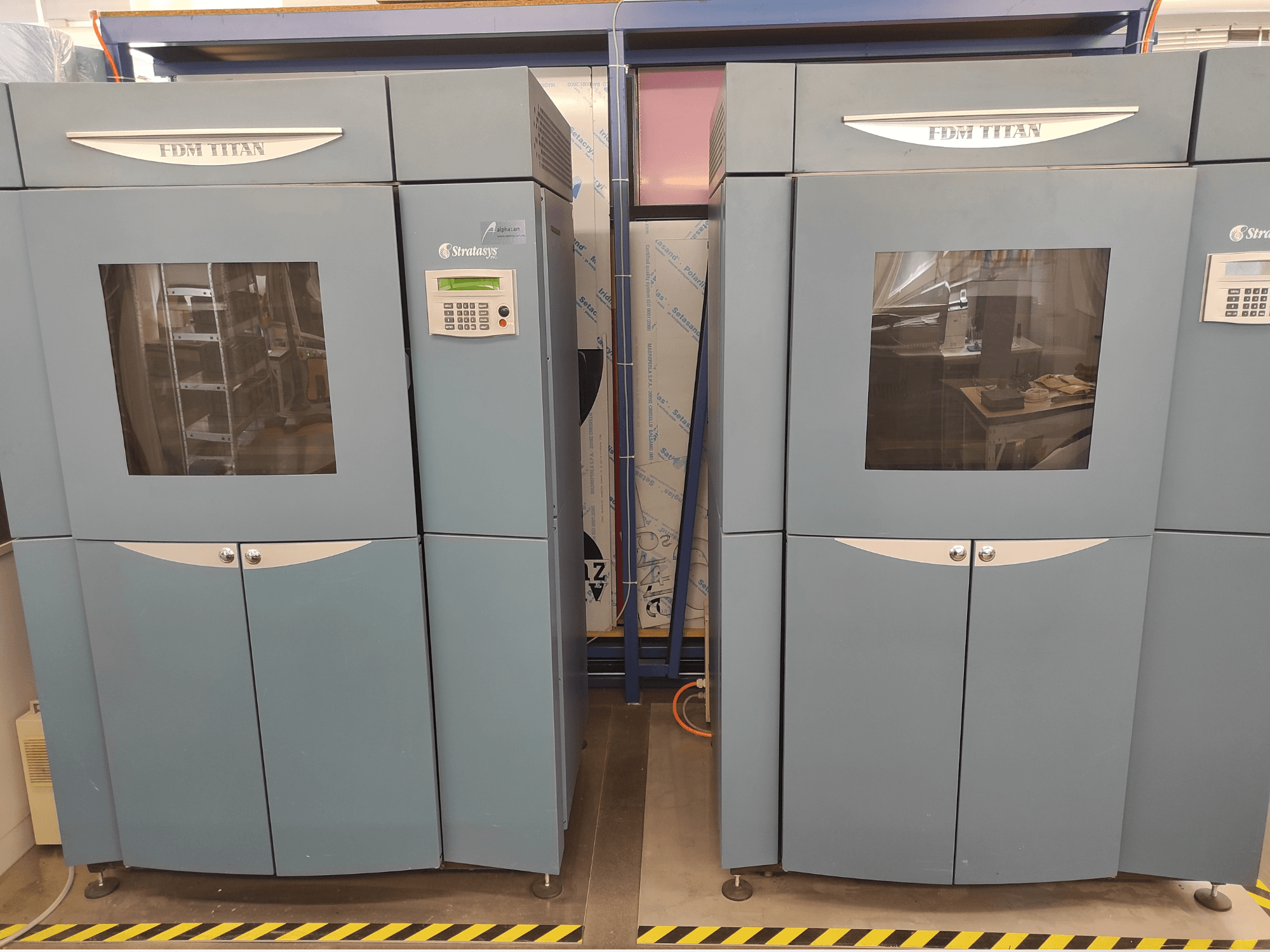 Stratasys FDM TitanTI T0031 plastik 3D yazıcının önden görünümü; ekran paneli ve şeffaf pencereye sahiptir.