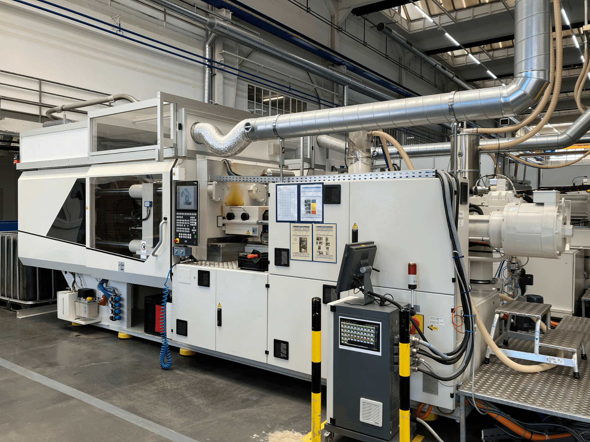 Şık beyaz tasarımı ve teknik detaylarıyla kontrol paneli, boruları ve ekranları olan endüstriyel bir makinenin önden görünümü.