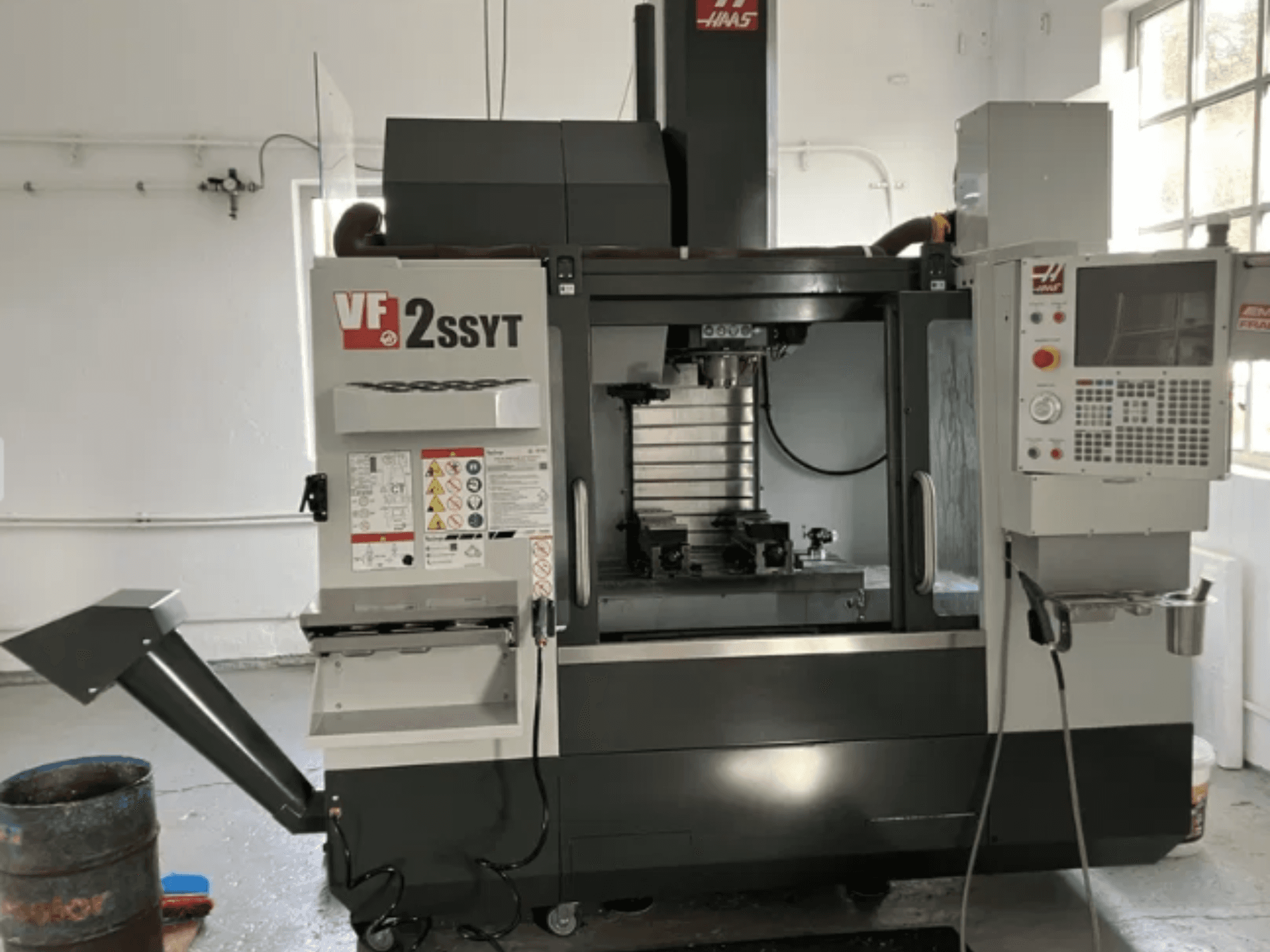 Haas VF-2SSYT CNC freze, önden görünüm, kontrol paneli, takım tutucu ve metal işleme için soğutma sistemi özellikleri.