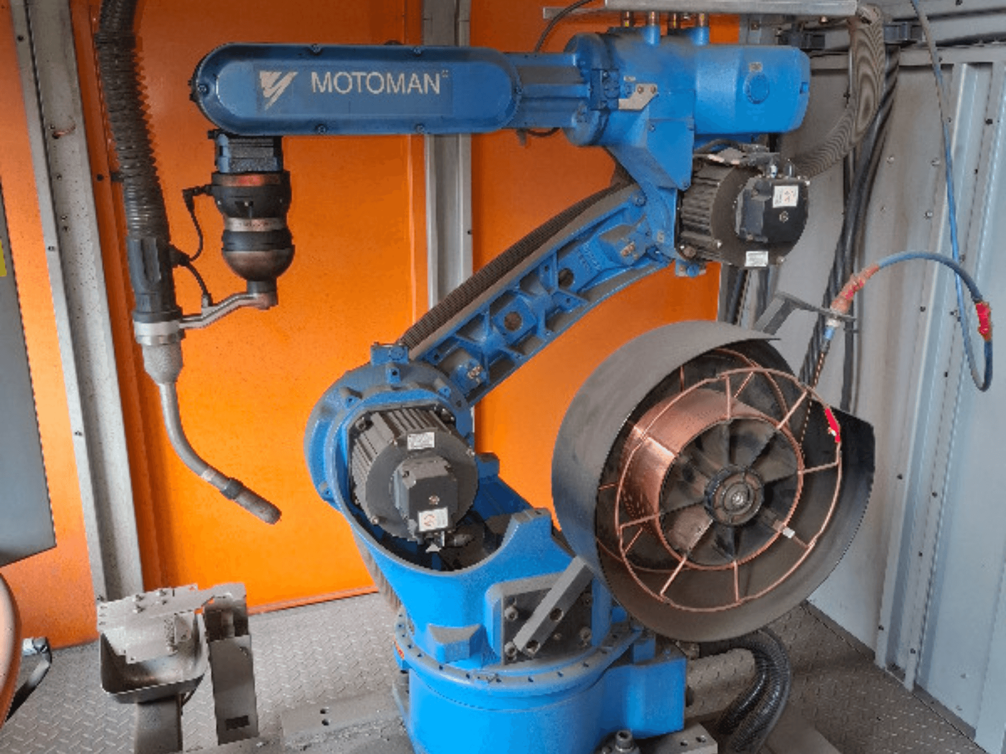 Mavi renkli MOTOMAN robot kolu, yandan görünüm, takılı fan ve takımlar, mekanik detaylar ve bağlantılar.