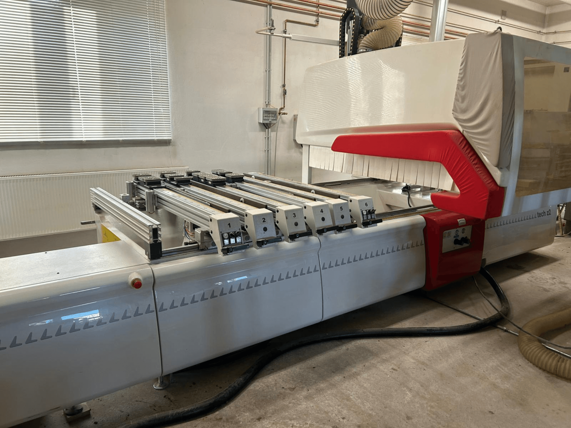 SCM TECH Z2-27-C ahşap delme makinesi, yandan görünüm, kontrol panelini ve rayları gösteren, kırmızı ve beyaz tasarım öğeleri.