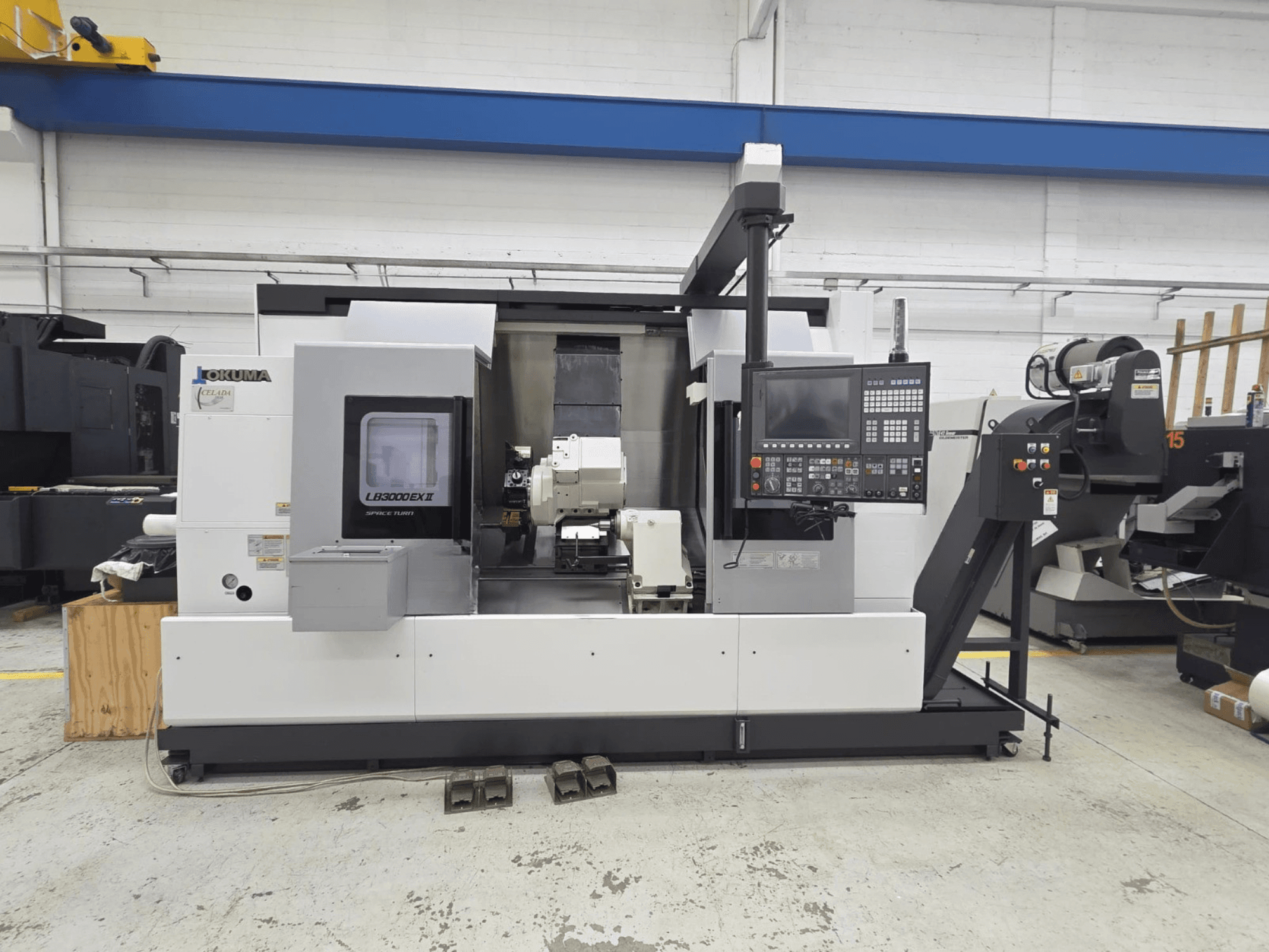 Okuma LB 3000 EXII yatay tornalama makinesi, kontrol paneli ve takım tutucusu ile önden gösterilmiştir.