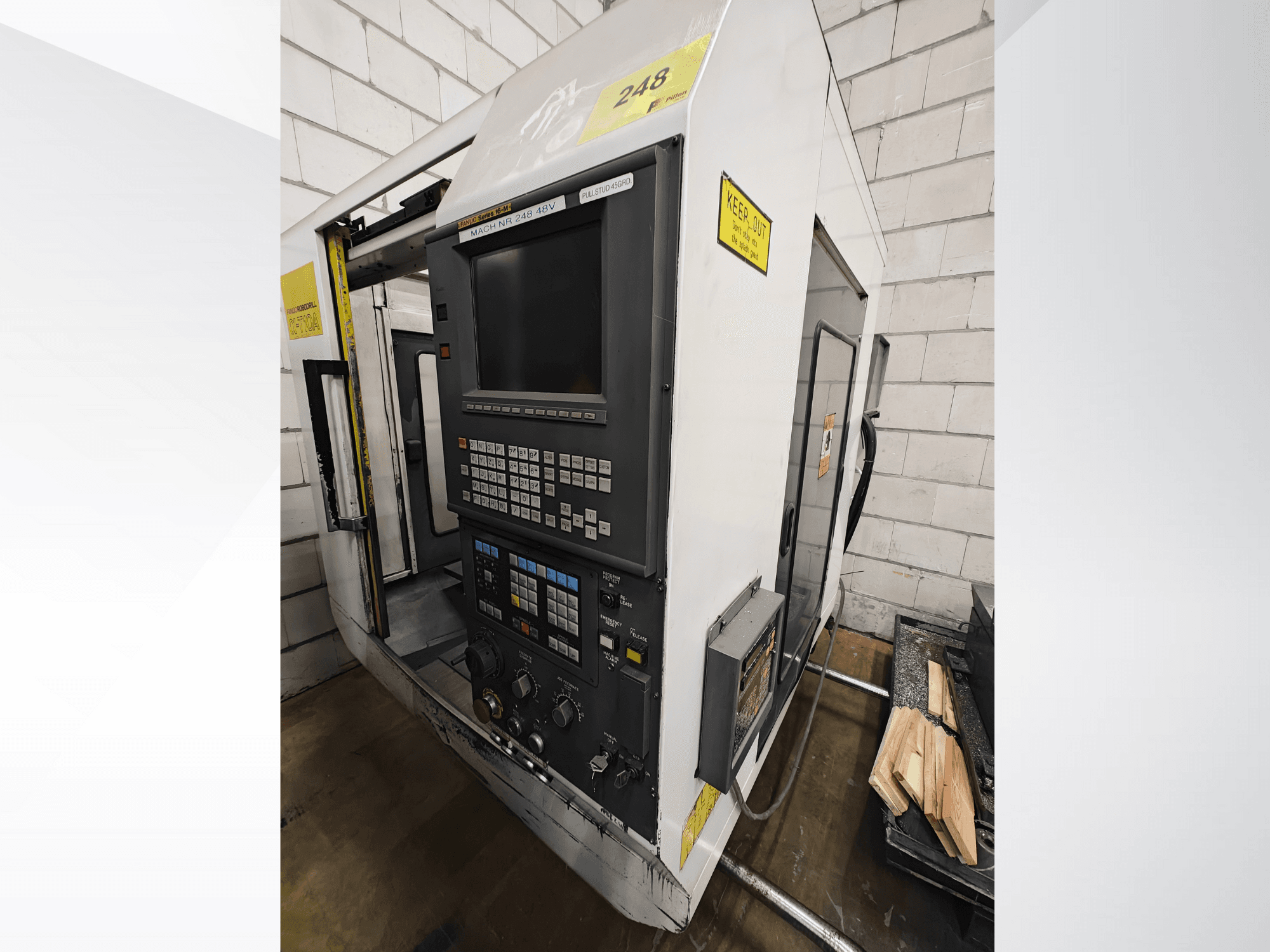 CNC makine modeli Nr 248, önden görünüm, düğmeli ve ekranlı bir kontrol paneli, yanında bir rafta ahşap parçalar.