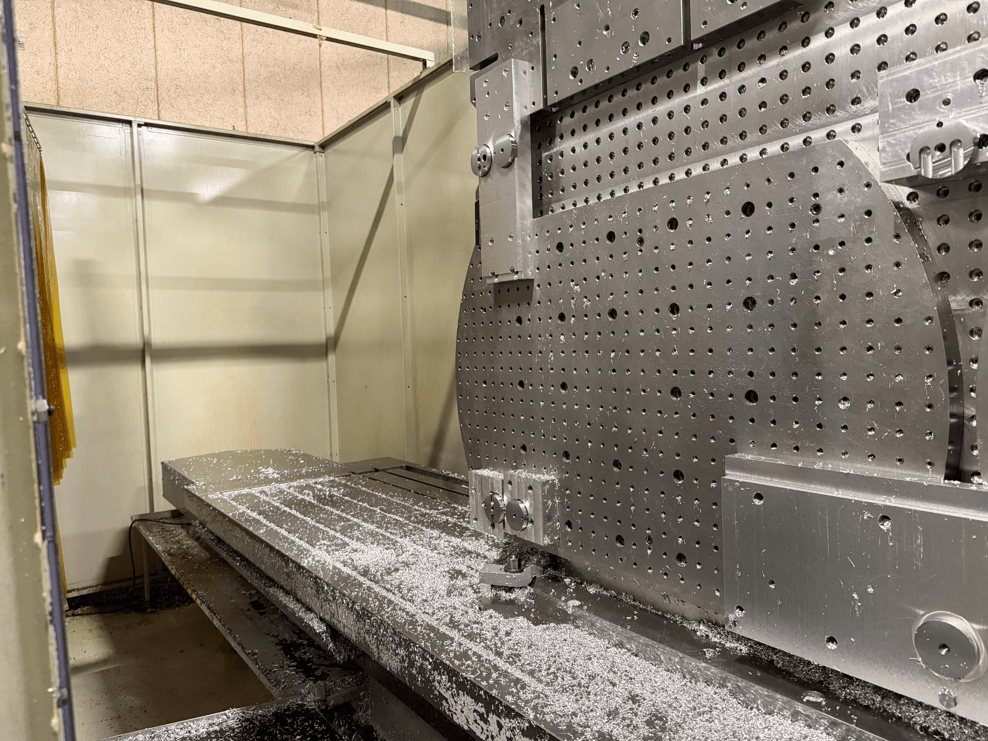 KIHEUNG KNC-U1000 Üniversal İşleme Merkezi'nin yakın çekim ön görünümü, alüminyum talaşı ile metal bir çalışma masasını göstermektedir.