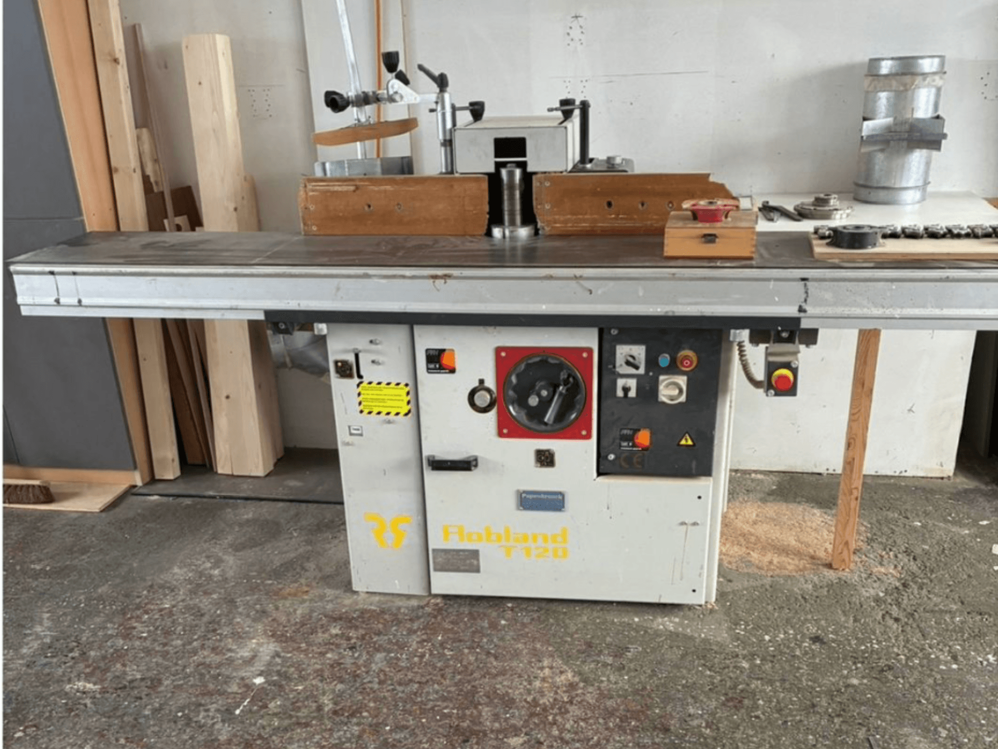 Hobbland T120 masa üstü planya, önden görünüm, gümüş bir yüzeye, düğmeli kontrol paneline ve güvenlik etiketlerine sahiptir.